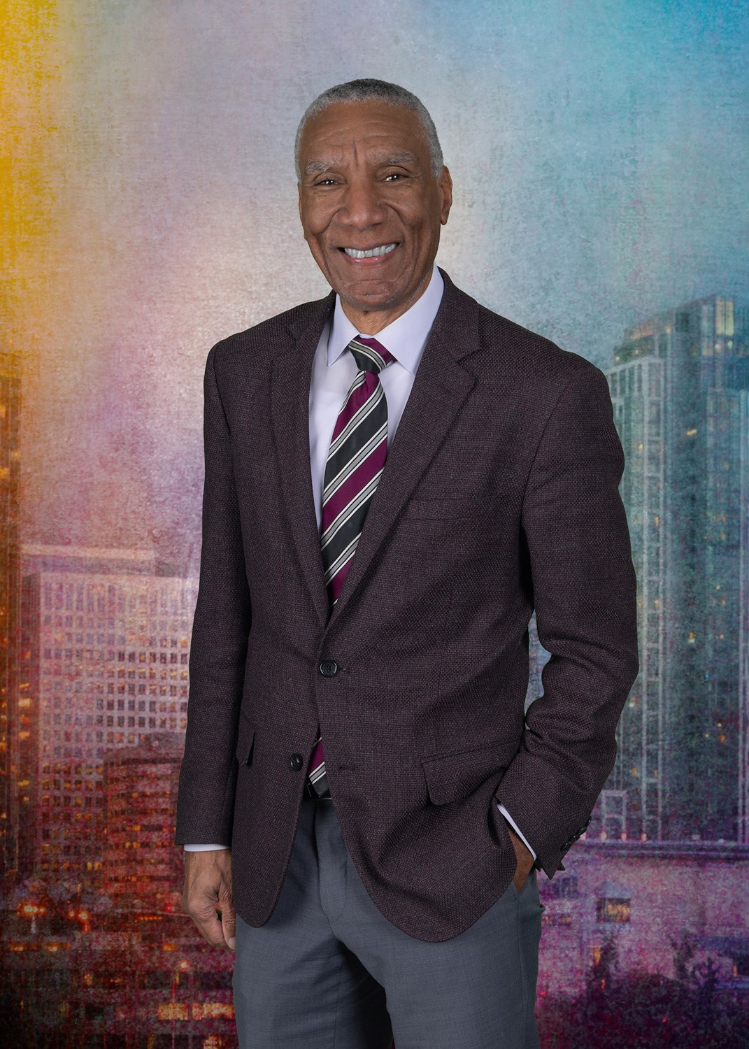 James McDonald's professional headshot in front of a colorful background. 