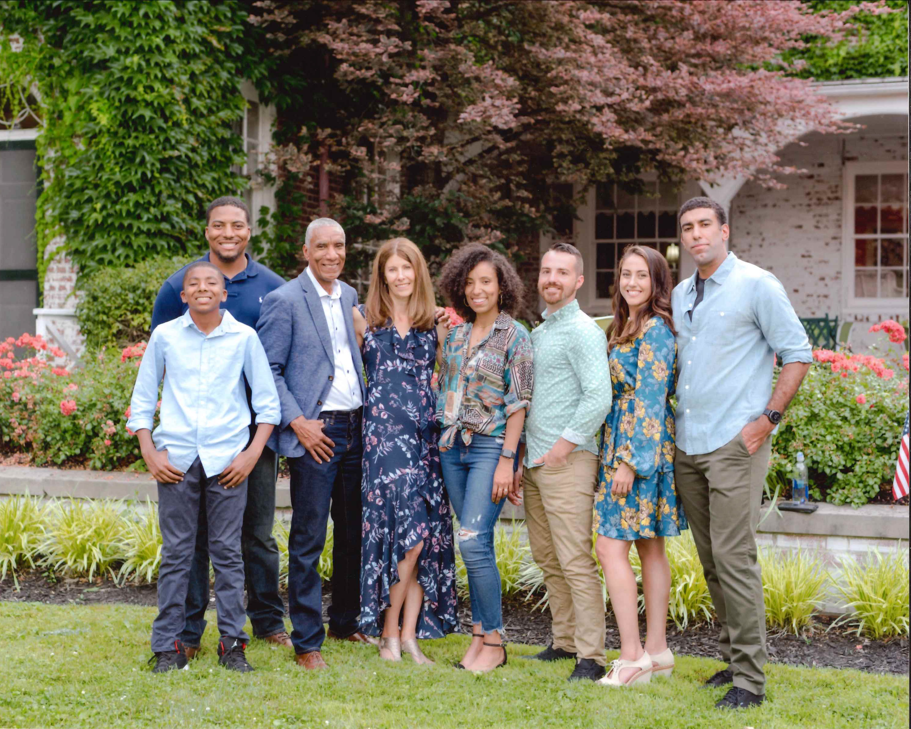 James McDonald, his wife, children, and grandchild posed in front of a landscaped background. 