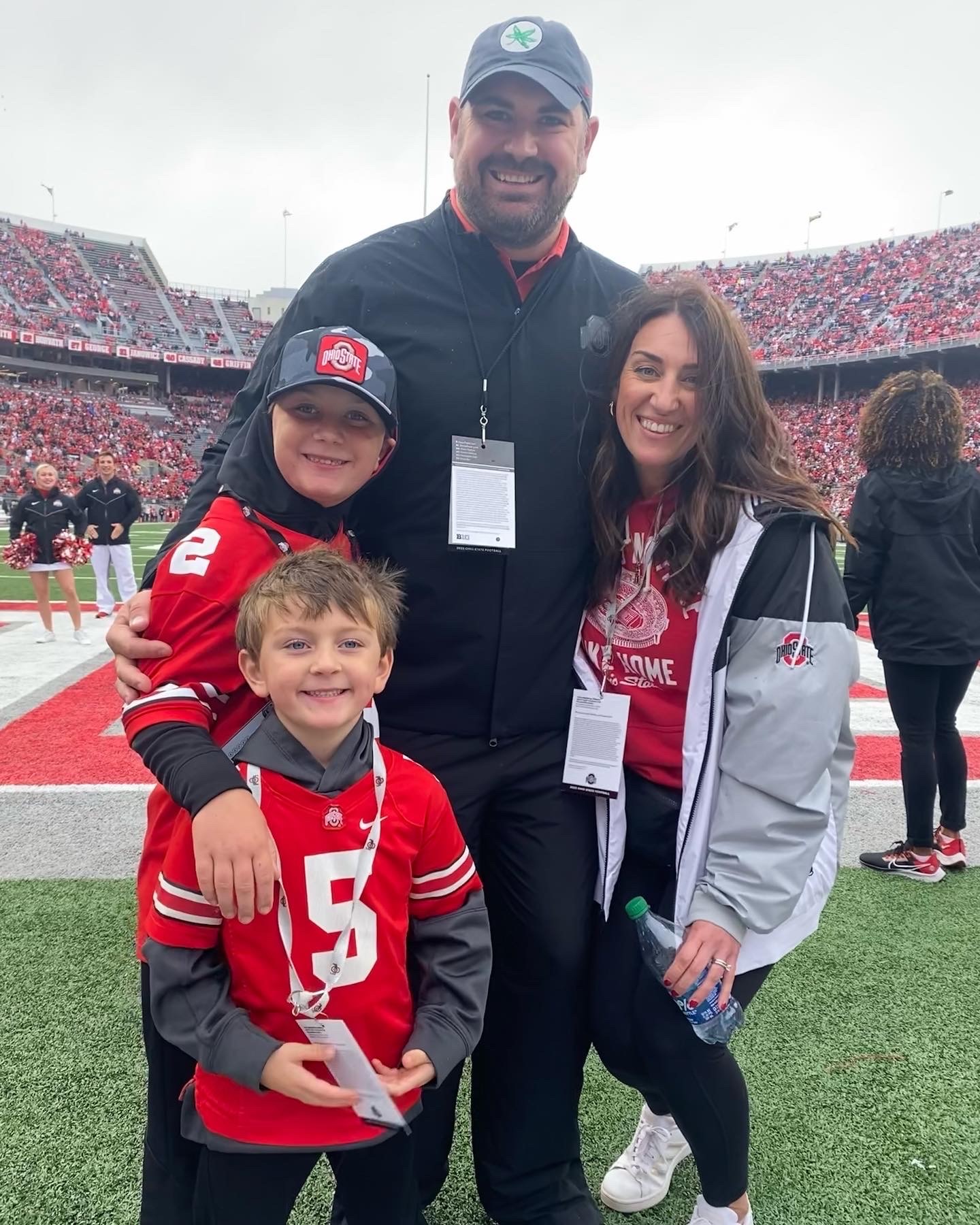Justin Kume, his wife, and two sons pose in Ohio State gear at the Ohio State football game. 