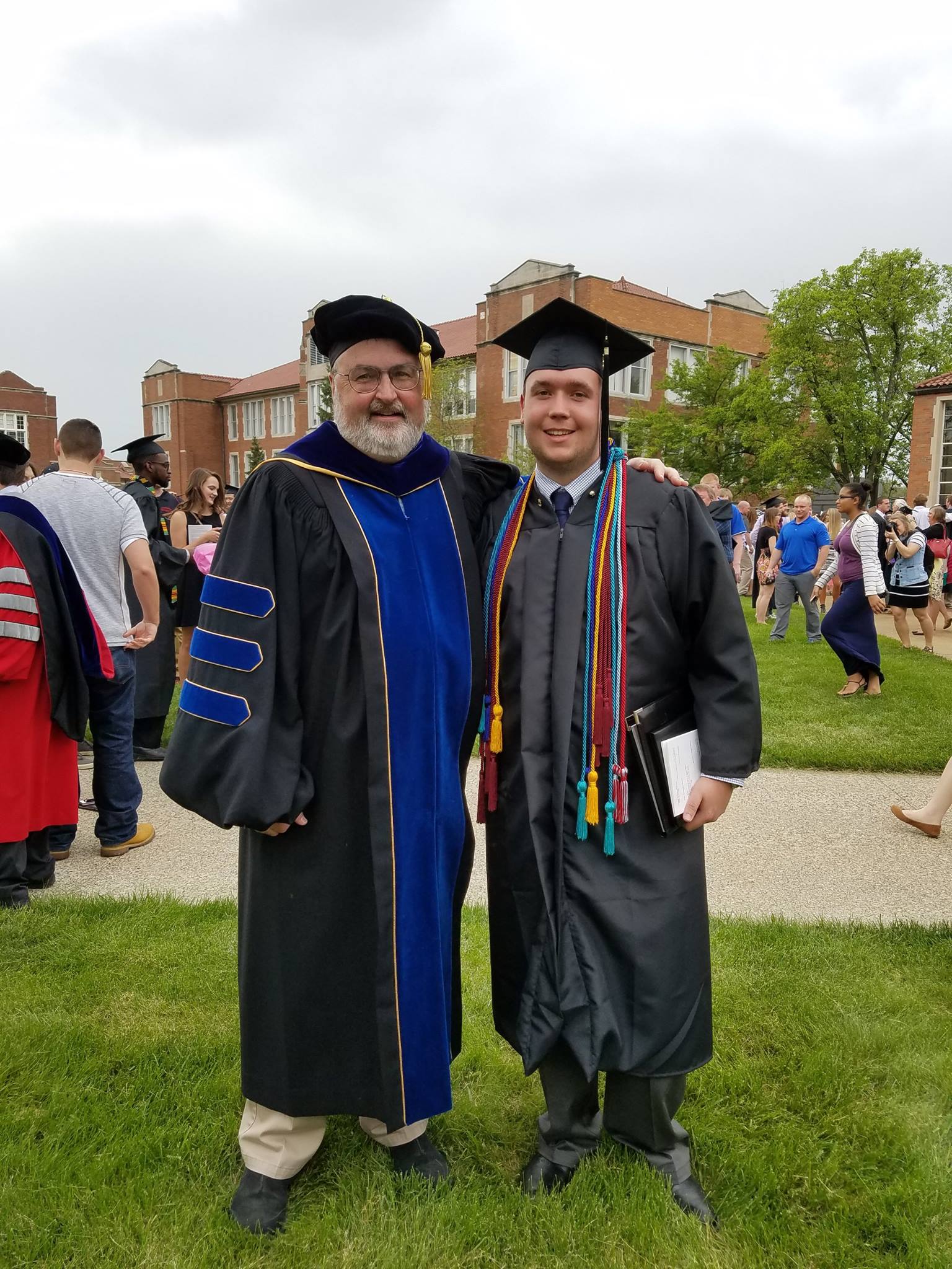 Taylor Loos-Little at Muskingum University commencement with a professor. 