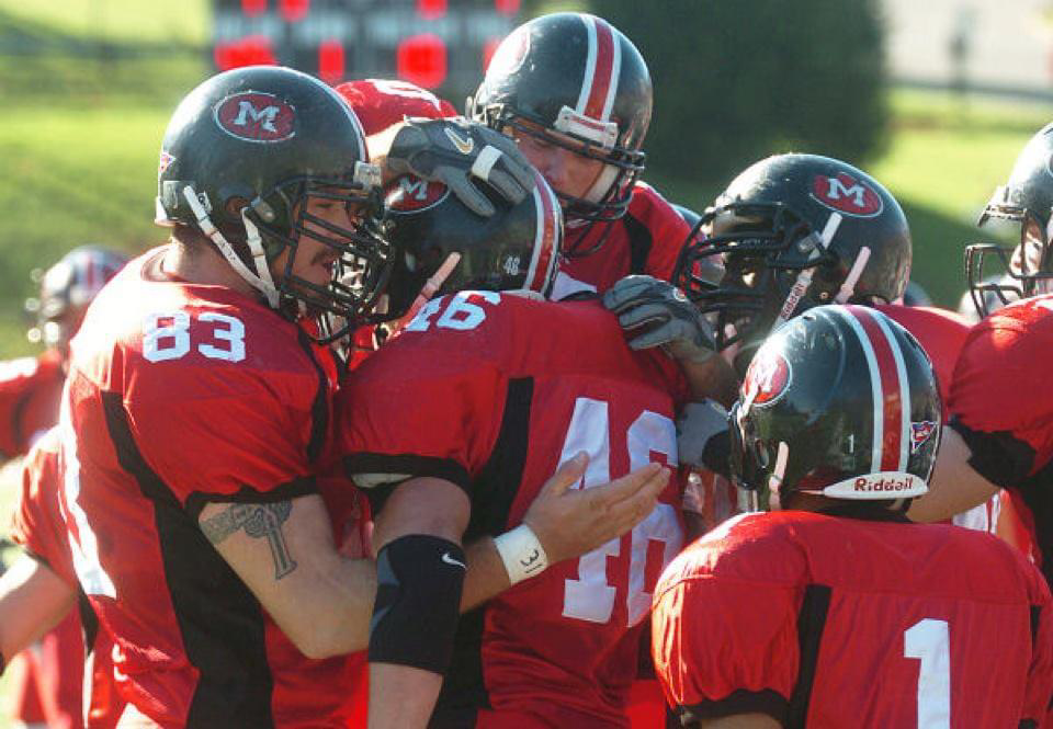 Justin Kume wearing a red jersey with a number eighty-three on it when he played football for Muskingum University. 