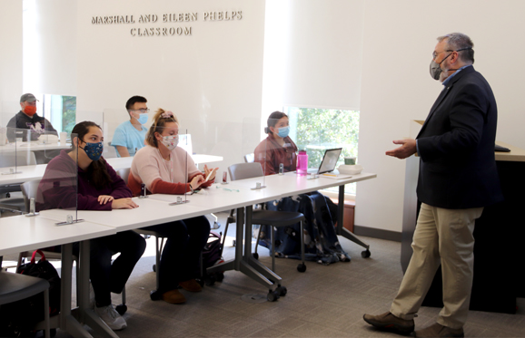 student in a classroom with a professor teaching