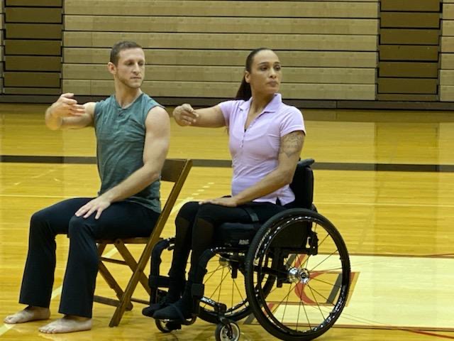 2 dancers in the Anne C. Steele Center performing, one female in a wheel chair, the other, male, sitting in a chair