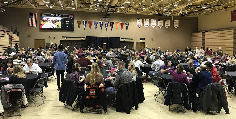 scholarship day participants sit around tables in the Anne C Steel Center gym, wide view of the whole gym includes many students