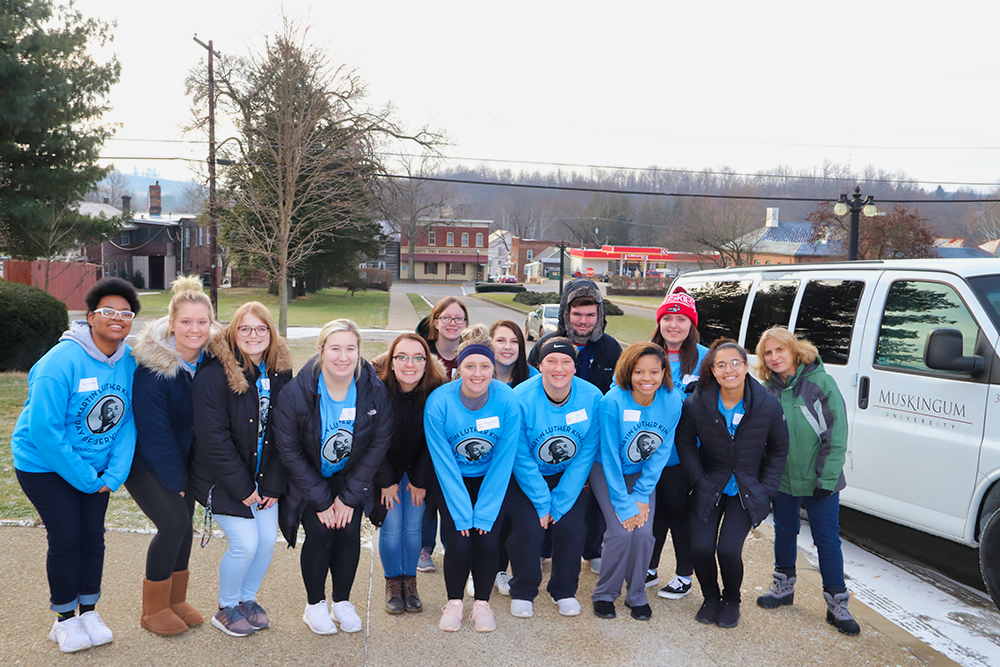 Group of students in front of Muskingum University van getting ready to deliver food to the local food pantry