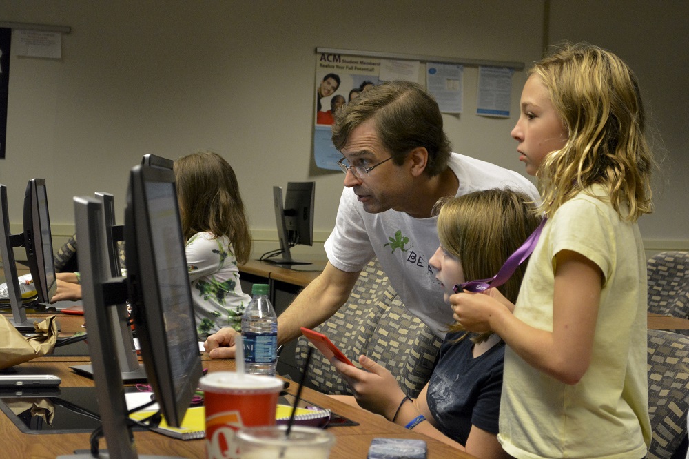 Professor Shaffstall working with students on a computer