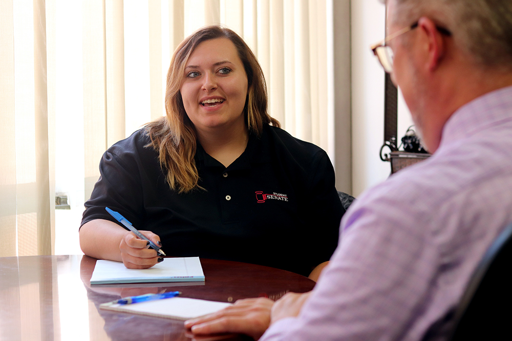 zoey stenson in a meeting wearing her black Student Senate polo