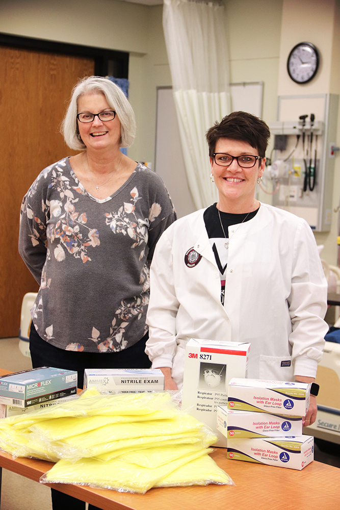 terra armstead and cindy wilkins posing in front of some of the supplies that were donated to help with the COVID-19 response