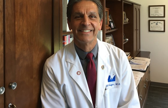 Bill Gegas in his office wearing his white lab coat