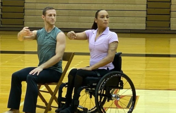2 dancers in the Anne C. Steele Center performing, one female in a wheel chair, the other, male, sitting in a chair