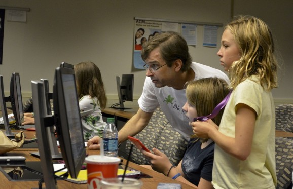 Professor Shaffstall working with students on a computer