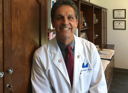 Bill Gegas in his office wearing his white lab coat