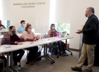 student in a classroom with a professor teaching