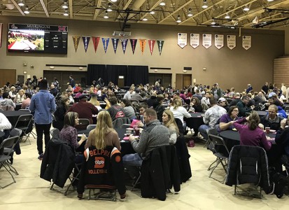 scholarship day participants sit around tables in the Anne C Steel Center gym, wide view of the whole gym includes many students