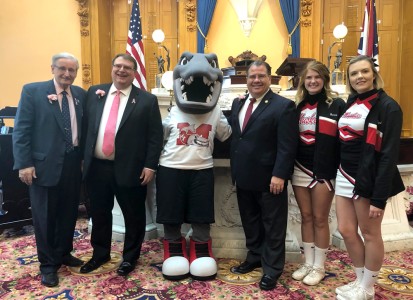 Pictured on the Ohio Senate Floor (L to R): Ohio Senate Minority Leader Kenny Yuko (D-Richmond Heights), Ohio Senate President Larry Obhof (R-Medina), Magnus, Senator Tim Schaffer (R-Lancaster), Muskie Cheerleaders